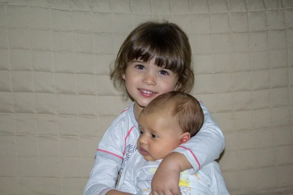 Wizerunek Uroczej Uśmiechniętej Dziewczynki Przytulającej Swojego Młodszego Braciszka Odniesienie Braterskiej — Zdjęcie stockowe