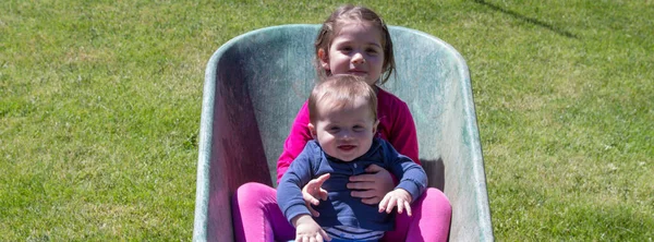 Wizerunek Dwójki Uroczych Uśmiechniętych Dzieci Trzymających Się Taczce Braterska Miłość — Zdjęcie stockowe
