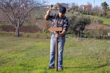 Yere çekiçle ok saplayan bir adamın görüntüsü. Yönü belirten kutup.