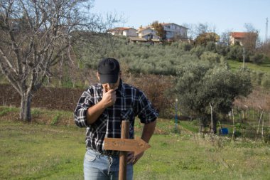 Kafası karışmış bir adamın yönünü belirten bir okla direğe bakması. Yolunu kaybetmiş bir adam