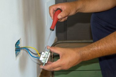 Elektrik prizi takan ve elektrik şoku alan bir elektrikçinin görüntüsü. İş güvenliği