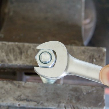 İngiliz anahtarıyla sürgüyü sıkan bir tamircinin eli. DIY atölyede çalışıyor.