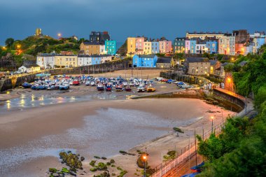 Güney Galler 'in popüler tatil beldesi tarihi Tenby Old Town' daki renkli evler ve limanlar akşam saatlerinde aydınlandı, Pembrokeshire, Birleşik Krallık