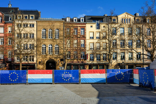 Historical houses on Place Guillaume II square in Luxembourg city center, decorated with flags of European Union and Duchy of Luxembourg