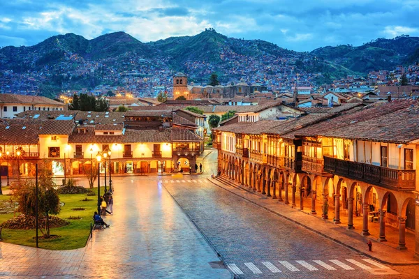 クスコ旧市街 ペルー メイン広場プラザ アルマス 聖フランシス教会と夕方にアンデス山脈のバルコニーとアーチを持つ伝統的な植民地時代のスタイルの家の景色 ストックフォト