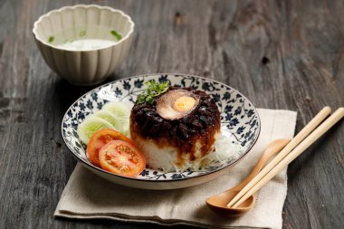 Nasi Tim Ayam, Endonezya mutfağı. Çin Etkisi Popüler Kahvaltı. Baharatlı tavuk ve tuzlu yumurtayla kaplı buharda pilav.. 