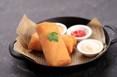 Çin usulü kızarmış karidesli börek, yanında da üç çeşit sos.