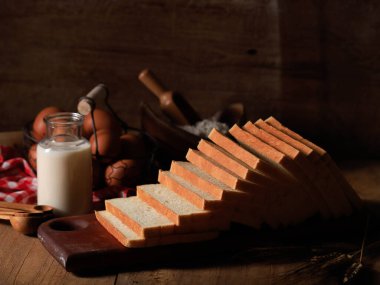 Tahta Arkaplanda Kahvaltı için Dilimlenmiş Tost Ekmeği (Shokupan veya Roti Tawar), Yumurta ve Sütle servis edilir. Fırın Kavram ResmiComment