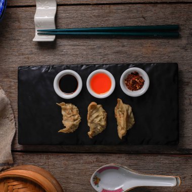 Gyoza, Steamed and Grilled Dumpling, Served with three kind Sauce on Black Stone Plate