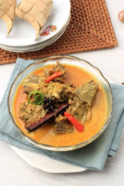 Gulai Sapi is Beef Curry Typically Traditional Food from Padang, West Sumatera, Indonesia. Served at the Table with Bowl and Ketupat Lebaran. Menu for Eid al Adha (Idul Adha)