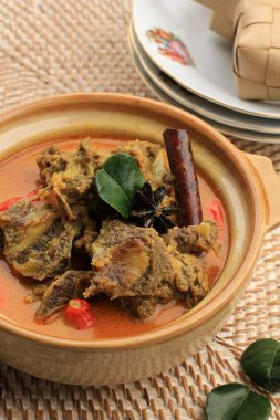 Close Up Gulai Sapi is Beef Curry Typically Traditional Food from Padang, West Sumatera, Indonesia. Served at the Table with Bowl and Ketupat Lebaran. Menu for Eid al Adha (Idul Adha)