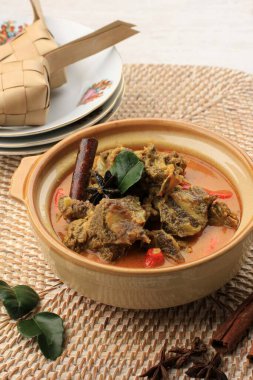 Gulai Sapi is Beef Curry Typically Traditional Food from Padang, West Sumatera, Indonesia. Served at the Table with Bowl and Ketupat Lebaran. Menu for Eid al Adha (Idul Adha)
