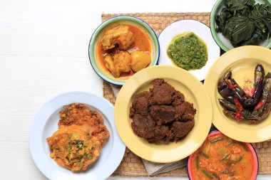 Various Homemade Masakan Padang or Minang Cuisine on WHite Background with Copy Space. Popular as Nasi Padang. 