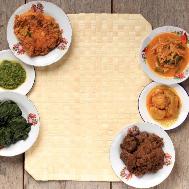 Selected Focus Various Menu of Padang Restaurant. Homemade Masakan Padang or Minang Cuisine on Rustic Background with Copy Space at the Center. 