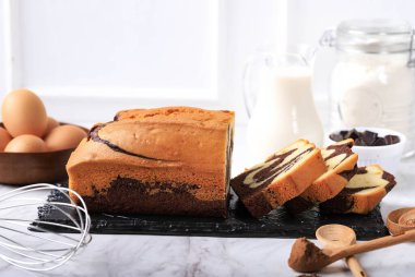 Homemade Chocolate and Vanilla Marble Loaf on Black Stone Plate with Slices Cake, White Background for Vintage Bakery Concept