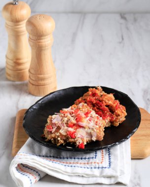 Ayam Geprek Sambal Matah is Popular Street Food in Indonesia. Made from Crispy Chicken Smashed in Sambal Matah (Balinese Chilli Sauce) . Usually Served with Rice and Vegetable