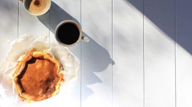 Top View Spanish Dessert, Basque Burnt Cheese Cake with Two Cup Coffee. Copy Space for Text, Recipe or Advertisement. Concept of Breakfast in the Morning