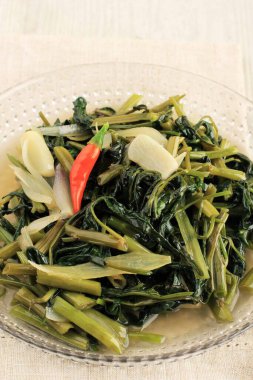 Stir-fried Water Spinach (Tumis Kangkung) is one of Indonesian Daily Menu and Favorite Food, Close Up on the Table