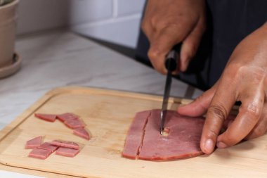 Asian Chef Female Hand Sliced Smoked Beef into Small Pieces. Cooking Process in the Kitchen 