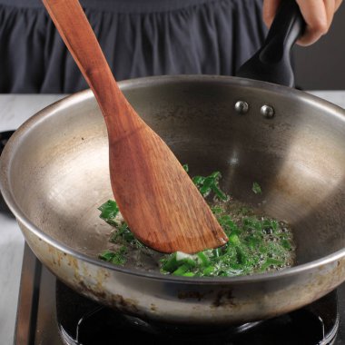 Selected Focus Sautee or Stir Fry Spring Onion in a Pan, Cooking Step by Step in the Kitchen Making Asian or Korean Food