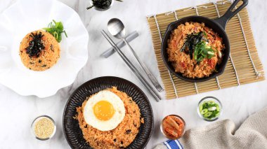 Top View Flat Lay Korean Fried Rice Kimchi Bokkeumbap with Egg, Laver or Nori, Spoon and Chopstick 
