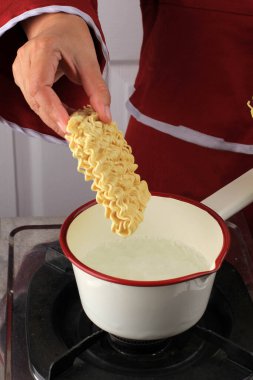 Boiling Instant Noodle on Sauce Pan, Add Noodle to the Pan, Home Cooking Activity