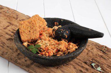 Selected Focus Sambal Tempeh, Spicy Crushed Tempe on Stone Pestle. Traditional Indonesian Food with Spicy and Savory Taste