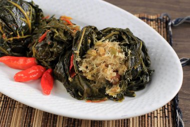 Buntil is Traditional Indonesian Food Made from Papaya/Cassava Leaves Stuffed with Grated Coconut, Petai Cina,  and Anchovy Fish. Popular in Javanese and Sundanese Cuisine, Copy Space Isolated