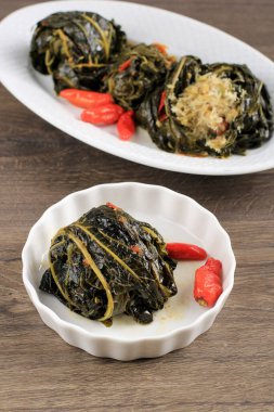 Buntil,  Spiced Shredded Coconut, Petai Cina, and Anchovy Fish Wrapped  with Papaya or Cassava Leaves. 