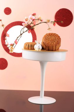Mooncake on Light Pink Background with Pink Flower. Concept Moon Cake on Mid Autumn Festival. Mooncake Popular as Kue Bulan.