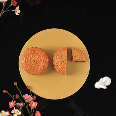 Mooncake on Light Pink Background with Pink Flower. Concept Moon Cake on Mid Autumn Festival. Mooncake Popular as Kue Bulan.