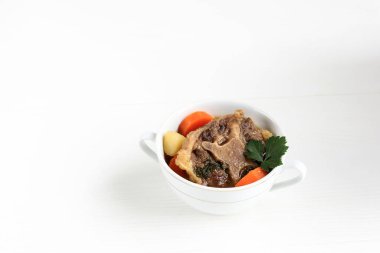 Indonesian Oxtail Soup or Sop Buntut on WHite Bowl, Isolated White Background