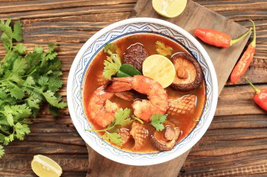 Tom Yum Goong baharatlı çorba Tayland 'da geleneksel yemek mutfağı ahşap arka planda