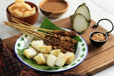 Sate Padang. Spicy Beef Satay from Padang, West Sumatra. Served with Spicy Curry Sauce and Lontong or Ketupat. Served On Enamel Plate