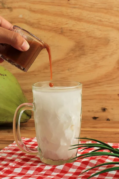 Pour Liquid Palm Sugar to Es Kelapa Muda, Young Coconut Ice, Sweet Cold Beverages Popular for Takjil in Ramadan Fasting Month