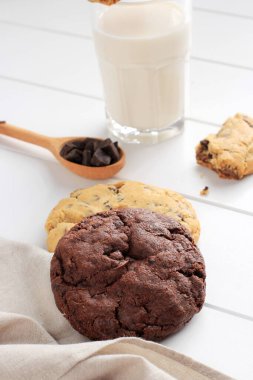 Soft American Cookies, Vanilla and Dark Chocolate Chips on White Wooden Table. Served with Milk 