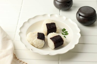Onigiri. Japanese Rice Triangle with Nori Seaweed on White Plate.