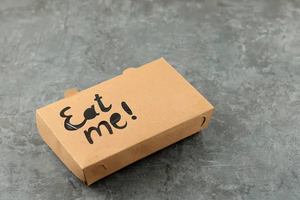 Paper Food Packaging for on the Go Meal with Eat Me Stamp on Top