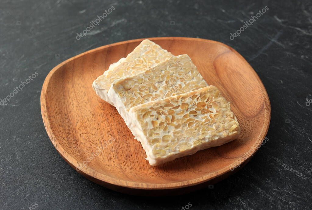 Tempe crudo en rodajas o empeh en placa de madera. Tempeh is Superfoods, Carne Alternativa