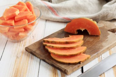 Tahta Masa 'da ince dilimlenmiş Papaya, Kupa' da küp portakal koparılmış Papaya. Diyet Konsepti 