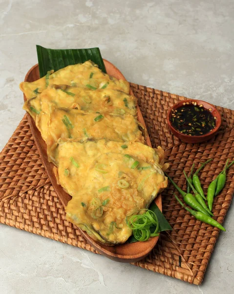 stock image Tempe Mendoan, Deep Fried Thin Sliced Tempeh Covered in Flour Batter with a Mixture of Green Onion and Spices. Served with Spicy Sweet Sou Sauce and Green Chilli