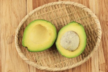 Slice Avocado on Rattan Plate, Above Wooden Table  clipart