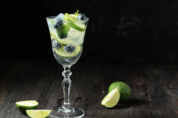 stock image Lime Blueberry Carbonate Water on Black Wooden Table. Copy Space for Text