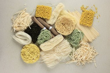 Various Type Raw Asian Noodle, Soba, Ramen, Ramyeon, Misua, Char Kway Teow, Vegetable Egg Noodle, Somen. Top View on Cream Table  clipart