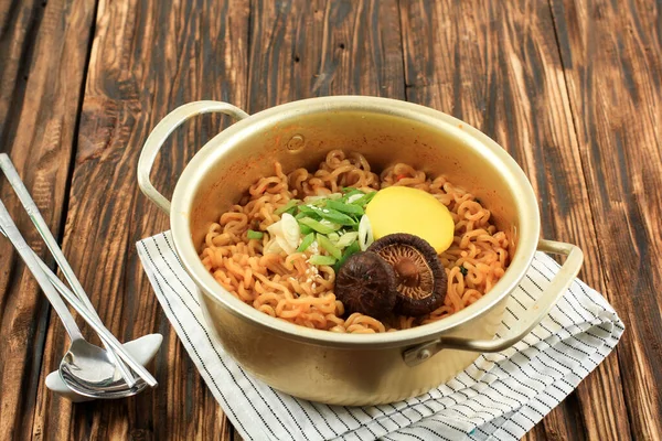 stock image Close Up Korean Style Instant Noodle, Ramyeon or Ramyun with Spicy Flavour topped with Mushroom, Spring Onion, Sesame Seed, and Danmuji. Served in Traditional Korean Noodle Pot.