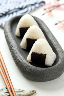 Onigiri, Japon Yemeği, Japon Pirinç Topu, Beyaz Masa Üzerinde Deniz Yosunu Nori Kuşağı olan pirinç üçgeni 