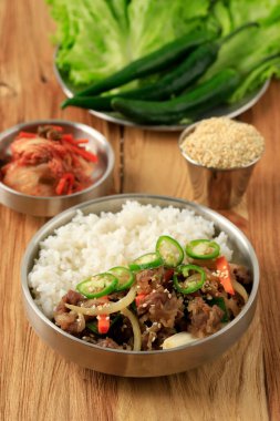 Taze sebzeli Kore Bulgogi Pirinci Kimchi ve Cheongyang Yeşil Biberli. Tahta Masa 'da 