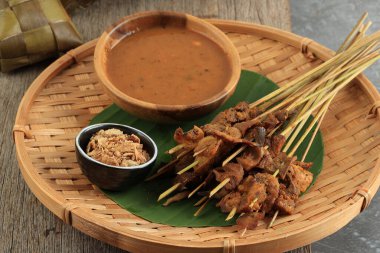 Sate Padang veya Satay Padang, Padang, West Sumatra 'dan Baharatlı Biftek Satay. Baharatlı Köri Sosu ve Ketupat Pirinç Keki ile servis edilir, Muz Yaprağı Uzunluğu.