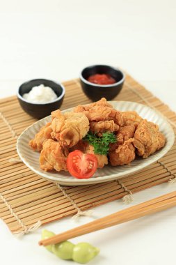 Karaage, Japon usulü kızarmış tavuk. Tek ısırık boyutunda, beyaz masa üzerinde.  