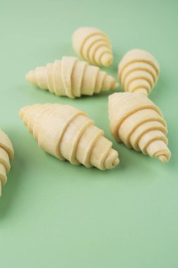 Çiğ kruvasan Pofuduk Yapılmamış Geleneksel Fransız kruvasanı Hamur rulosu Nane Yeşili Arkaplanda